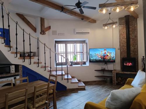 a living room with a staircase and a tv at Rincones de Darío: Capítulo II in Puerto Lápice