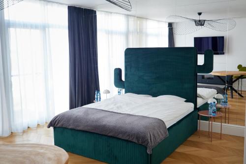 a bedroom with a bed with a green headboard at Apartament z widokiem na jezioro in Charzykowy
