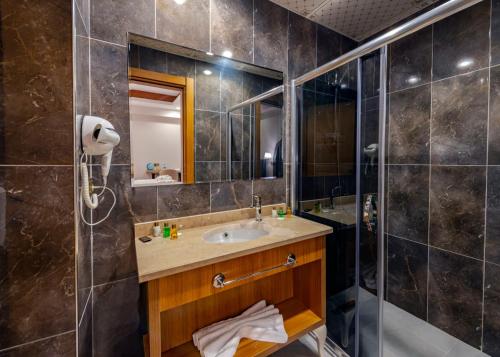 a bathroom with a sink and a shower at IŞIL PARK HOTEL in Kars