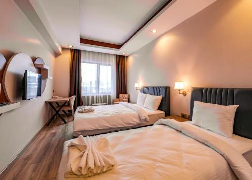 IŞIL PARK HOTEL في كارس: غرفة فندقية بسريرين وتلفزيون