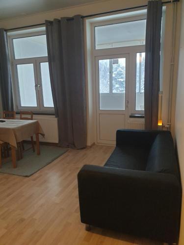a living room with a couch and a table and windows at The old school motell & lägenheter in Marma