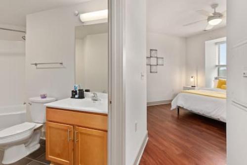 a bathroom with a sink and a toilet and a bed at Affordable 2-Bedroom DT Detroit. in Detroit