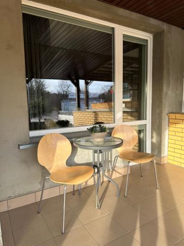 a glass table and chairs on a balcony with a window at Zajazd Irina in Białystok