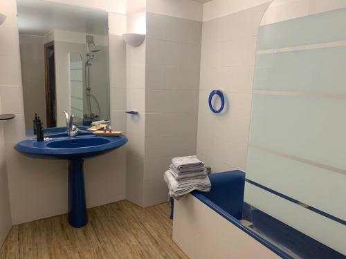 Hotel La Fuste في فالونسول: حمام مع حوض أزرق ودش