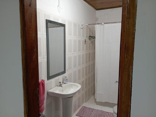 La salle de bains est pourvue d'un lavabo, d'un miroir et d'une douche. dans l'établissement Casa amoblada en Villarrica - Py, à Villarrica