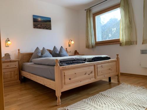 ein Schlafzimmer mit einem Holzbett und einem Fenster in der Unterkunft Chalet Leitn-Anger in St. Leonhard in Passeier