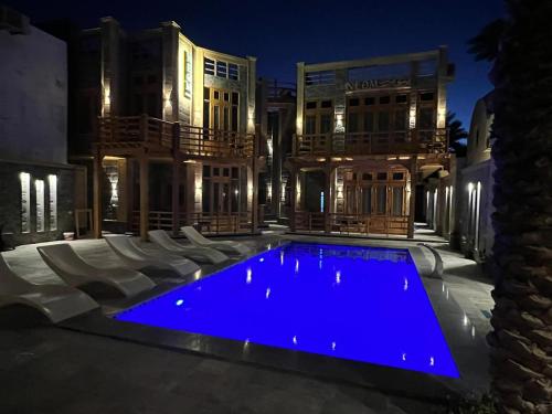 a swimming pool in front of a house at night at Village Light House Dahab in Dahab
