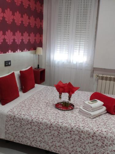 - une chambre avec un lit doté d'oreillers rouges et d'un plateau dans l'établissement Hostal Inn Madrid, à Madrid