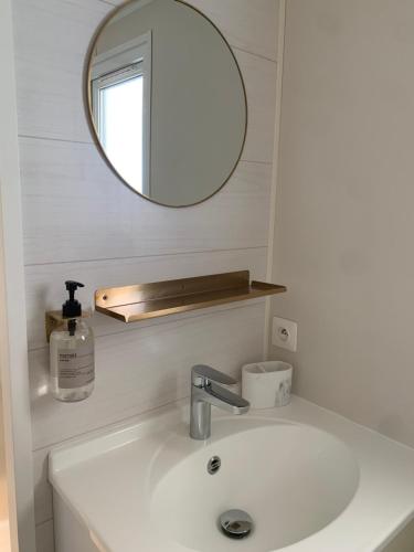 - un lavabo blanc dans la salle de bains avec un miroir et un lavabo dans l'établissement Superbe Bungalow sur la plage de Pampelonne Ramatuelle, à Saint-Tropez