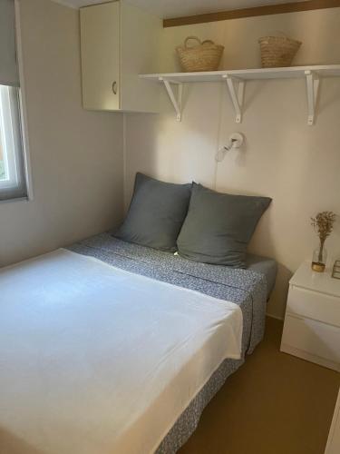 - une petite chambre avec un lit et des étagères dans l'établissement Superbe Bungalow sur la plage de Pampelonne Ramatuelle, à Saint-Tropez