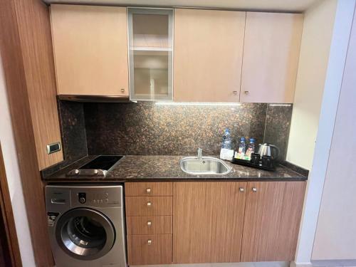 a kitchen with a sink and a washing machine at Maria s Single Room with Gym and Bar in Jounieh