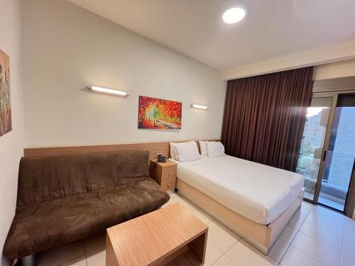 Habitación de hotel con cama y sofá en Mabelle s Room with Gym and Bar en Jounieh