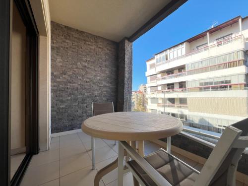 a table on a balcony with a view of a building at Maria s Single Room with Gym and Bar in Jounieh