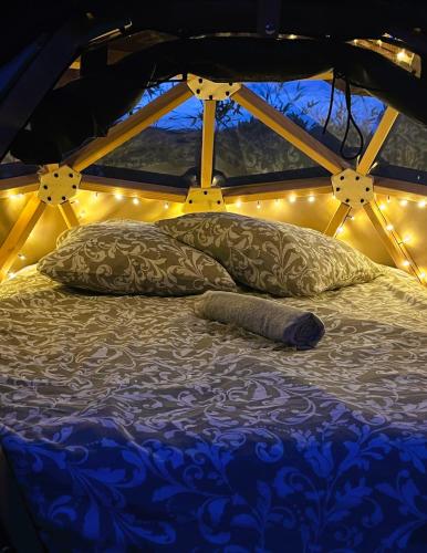 - un lit avec des oreillers et des lumières dans l'établissement Dodôme Véga Provence étoilée, à Rocbaron
