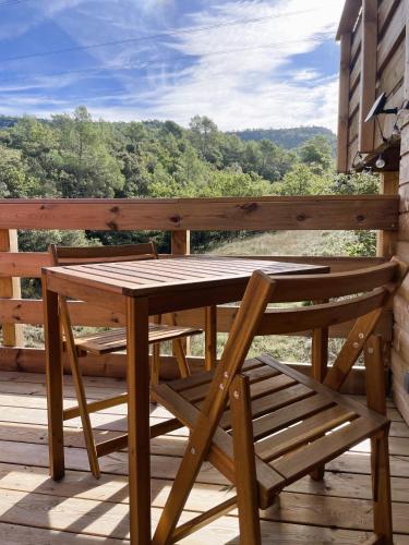 une table et un banc en bois assis sur une terrasse dans l'établissement Dodôme Véga Provence étoilée, à Rocbaron
