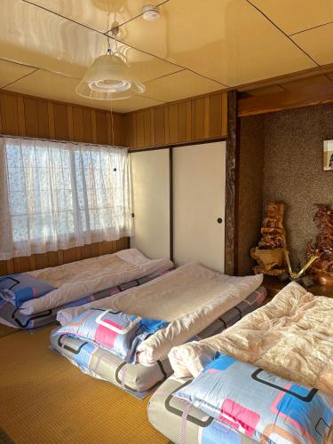 a room with four beds in it with a window at 水雲間民宿 in Furano