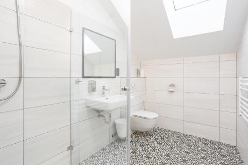 biała łazienka z toaletą i umywalką w obiekcie Ubytování Osové w mieście Velké Meziříčí
