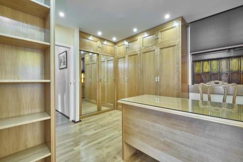 a walk in closet with wooden cabinets and a glass counter at Apartamento de lujo in Madrid
