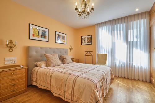 a bedroom with a large bed and a chandelier at Apartamento de lujo in Madrid