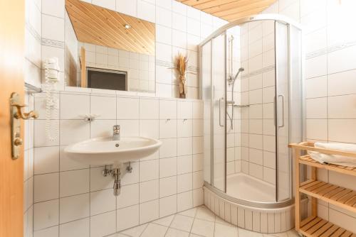 a white bathroom with a shower and a sink at Resort Amadeus-Landhaus Amadeus in Gröbming