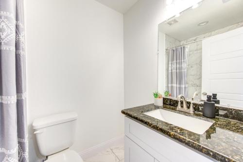 Baño blanco con lavabo y espejo en Townhome in Houston, en Houston
