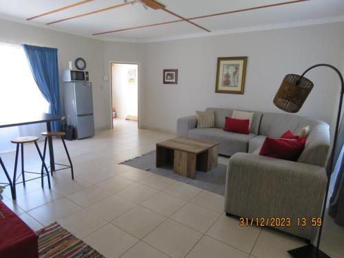 uma sala de estar com um sofá e uma mesa em Be My Guest em Swakopmund