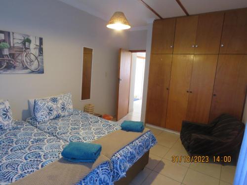 a bedroom with a bed with blue sheets and a cabinet at Be My Guest in Swakopmund