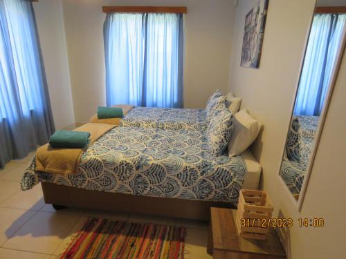 Dormitorio pequeño con cama y espejo en Be My Guest en Swakopmund