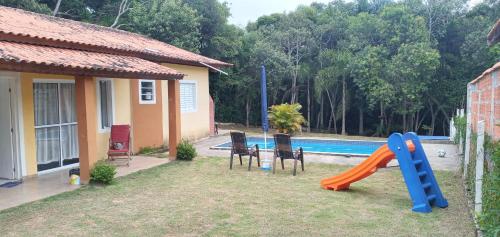 un patio trasero con un tobogán y una piscina en Espaço Life ibiuna, en Ibiúna