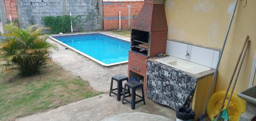 un patio trasero con piscina al lado de una casa en Espaço Life ibiuna, en Ibiúna