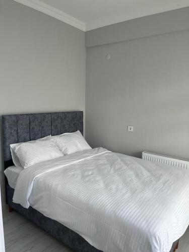 a bedroom with a large bed with white sheets at 6 şubat apartmanı in Avanos