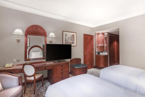 a hotel room with a desk and a bed and a bedroom at Madinah Hilton Hotel in Al Madinah