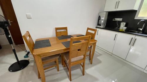 a kitchen with a wooden table and some chairs at Rani Suite and Cabin in Kandy