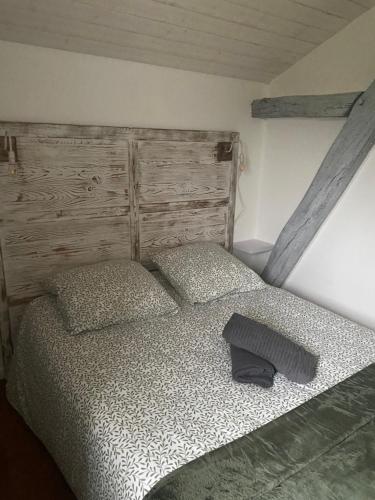 1 dormitorio con 1 cama con cabecero de madera en Maison individuelle, en Villecomtal-Sur-Arros