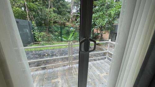 a sliding glass door with a view of a garden at Rani Suite and Cabin in Kandy