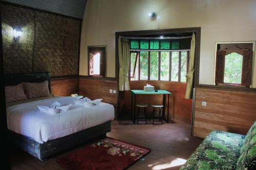 Un dormitorio con una cama y una mesa. en Lamina Repoq Hiils, en Kuta Lombok