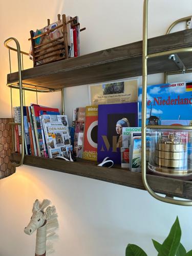 a shelf with books and a toy horse on a wall at B&B Ereprijs in The Hague