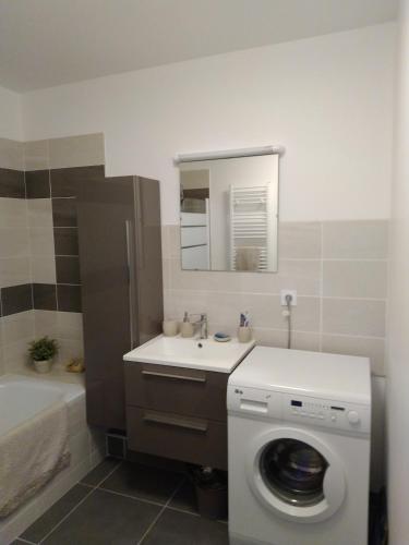une salle de bain avec une machine à laver et un lavabo dans l'établissement Beau T3 + clim + parking Saint Cyr sur mer, à Saint-Cyr-sur-Mer