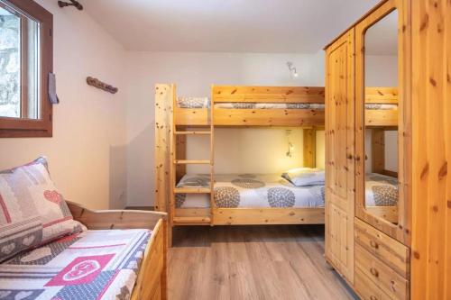 a bedroom with two bunk beds and a bed at Chalet Chez Maxime Hameau l’Archaz Valloire in Valloire