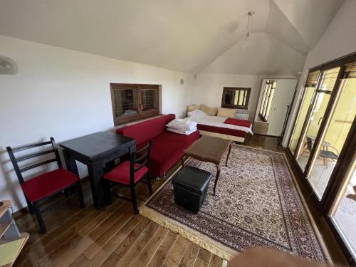 サラエボにあるVilla Forest Sarajevoのベッド、テーブル、椅子が備わる客室です。