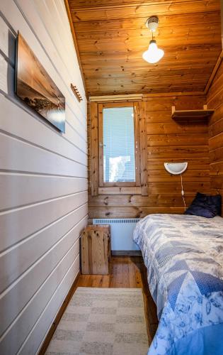 a bedroom with a bed in a wooden cabin at Lomariihi 2 in Muurame