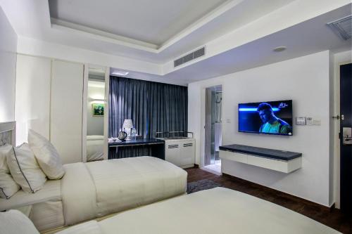 a bedroom with a bed and a tv on a wall at Grace 21 Smart Hotel in Dhaka