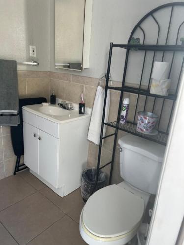 een badkamer met een wit toilet en een wastafel bij bedroom private in Miami
