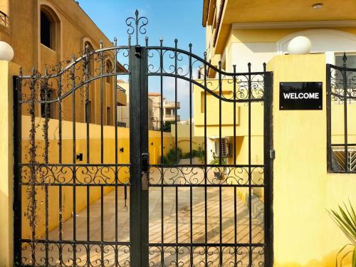 a gate in front of a building with a yellow bus at BIRD NEST Near Arkan Plaza in Cairo
