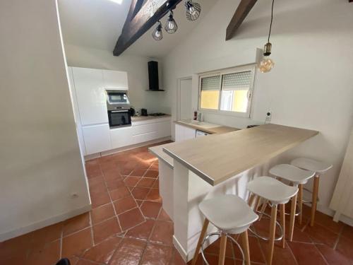 a kitchen with a counter and stools in a room at Maison a deux pas de Perigueux quartier calme. in Coulounieix-Chamiers