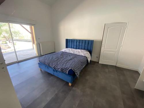 um quarto com uma cama azul e uma janela em Maison a deux pas de Perigueux quartier calme. em Coulounieix-Chamiers