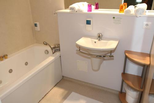 a bathroom with a sink and a toilet and a bath tub at Rev'hotel in Ribérac