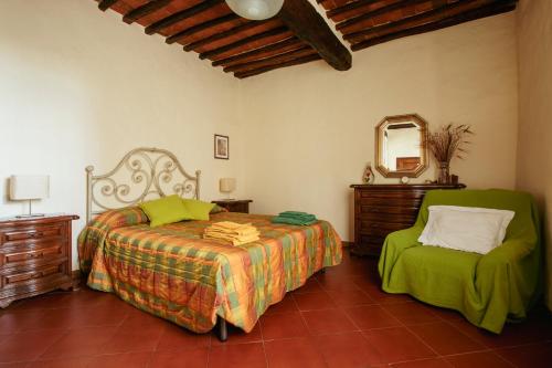 a bedroom with a bed and a mirror and a chair at Heart of Chianti - a warm flat in Radda in Radda in Chianti