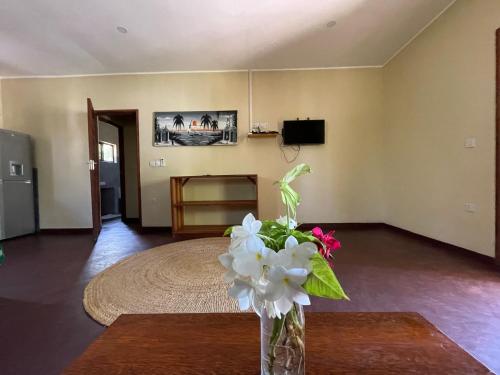 a living room with a vase of flowers on a table at Diana Place in Paje
