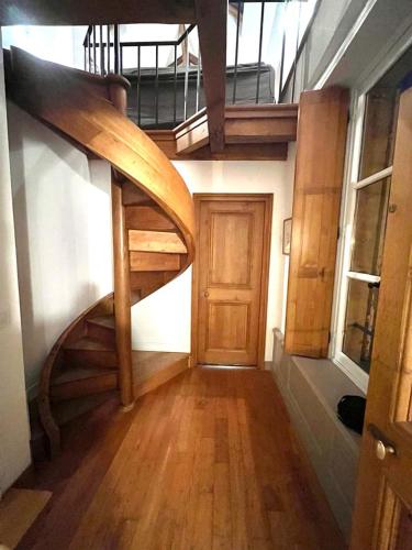 un couloir avec un escalier en colimaçon en bois dans un bâtiment dans l'établissement Tropical Duplex in Senlis, à Senlis